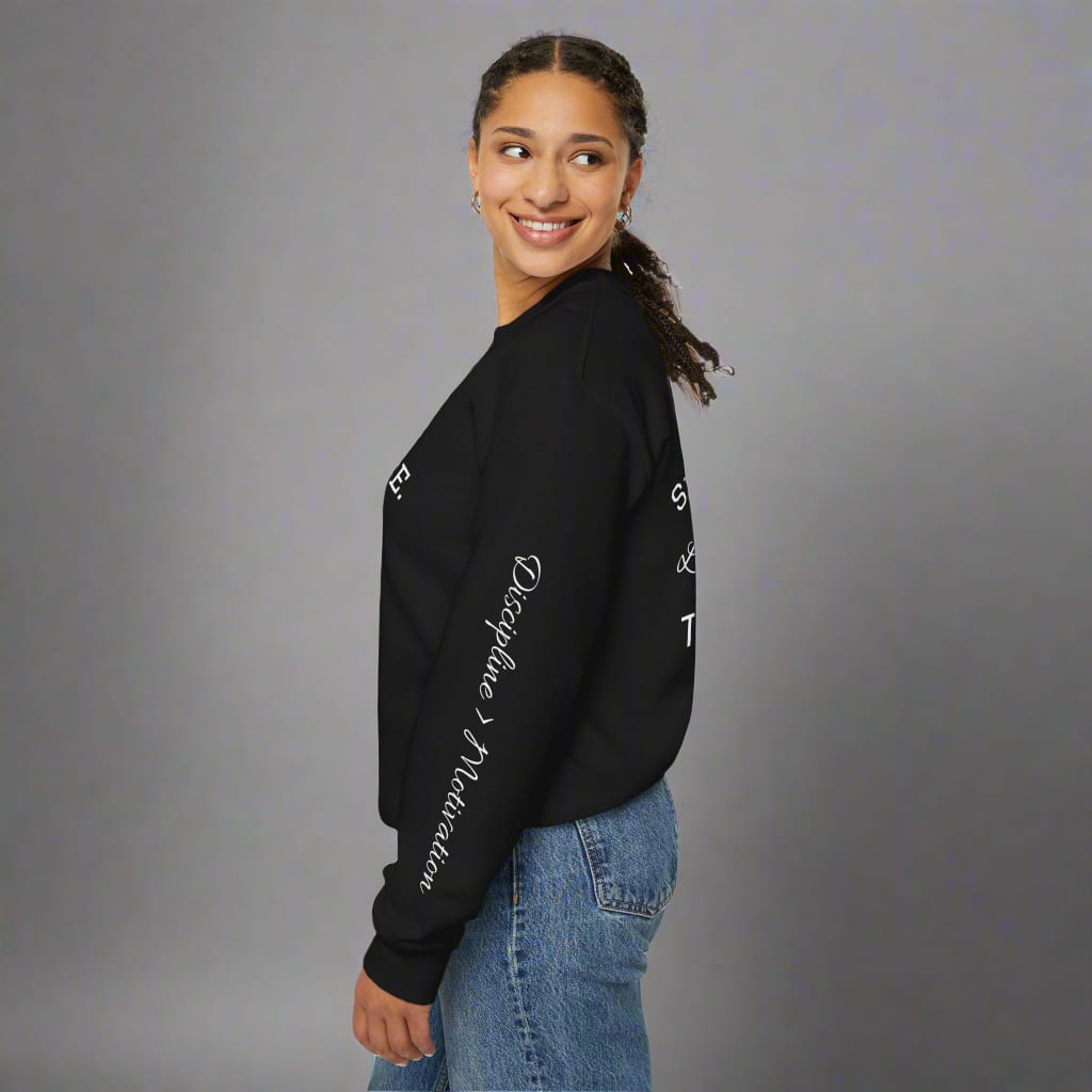 Side view of model in black motivational sweatshirt